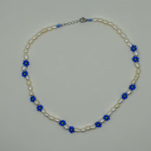 Load image into Gallery viewer, Eine handgefertigte Perlenkette mit Gänseblümchen-Motiven, gemeinsam mit einer türkischen Kunsthandwerkerin hergestellt. Die Perlen sind naturbelassen und variieren in Form, Größe und Farbe. Die Kette wird in einem kleinen Stoffbeutel zur AufbewahrEine handgefertigte Perlenkette mit Gänseblümchen-Motiven, gemeinsam mit einer türkischen Kunsthandwerkerin hergestellt. Die Perlen sind naturbelassen und variung geliefert. Der Ton ist elegant und herzlich und betont Handwerkskunst sowie kulturelle Authentizität.
